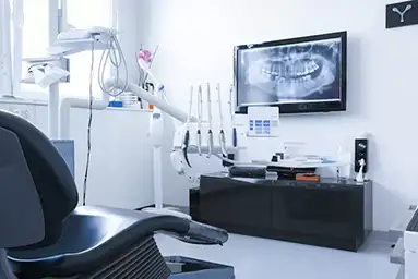 dentist office with chair, dental equipment and tv showing dental X-ray