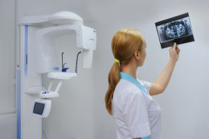 Dentist Analyzes A Dental Panoramic X-ray Film